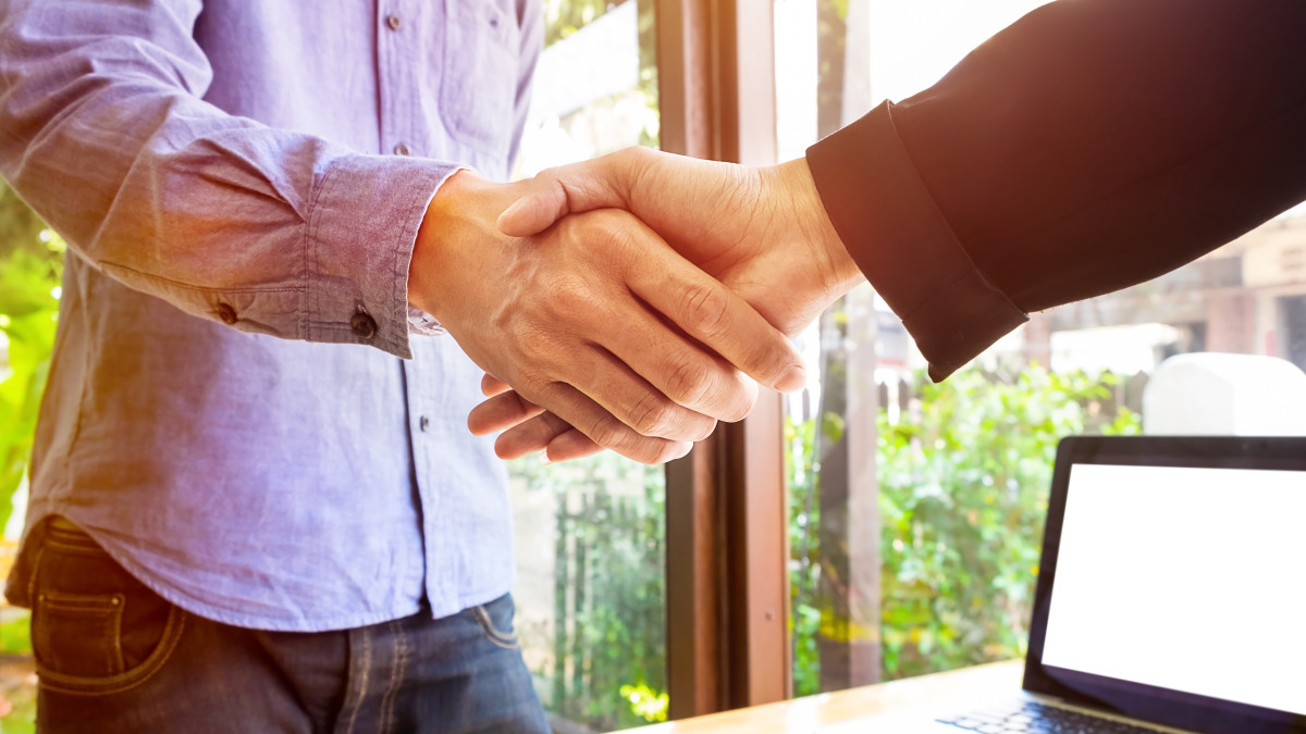 Une poignée de main entre deux hommes devant un bureau
